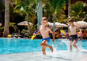 two young boys playing in shallow water with water guns