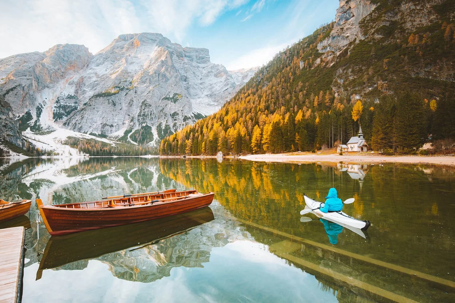 Kayaker on a serene lake with a mountain view