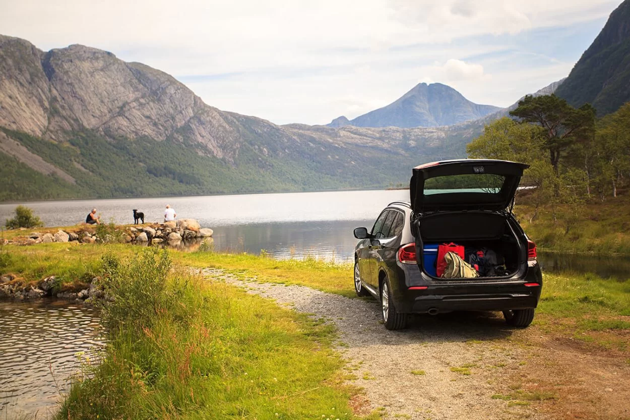 Car parked next to the water with the trunk open