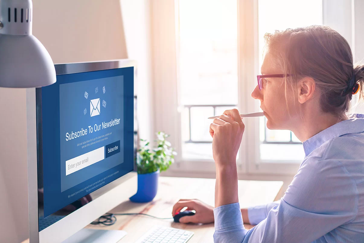 Women looking at computer screen that says subscribe to our newsletter