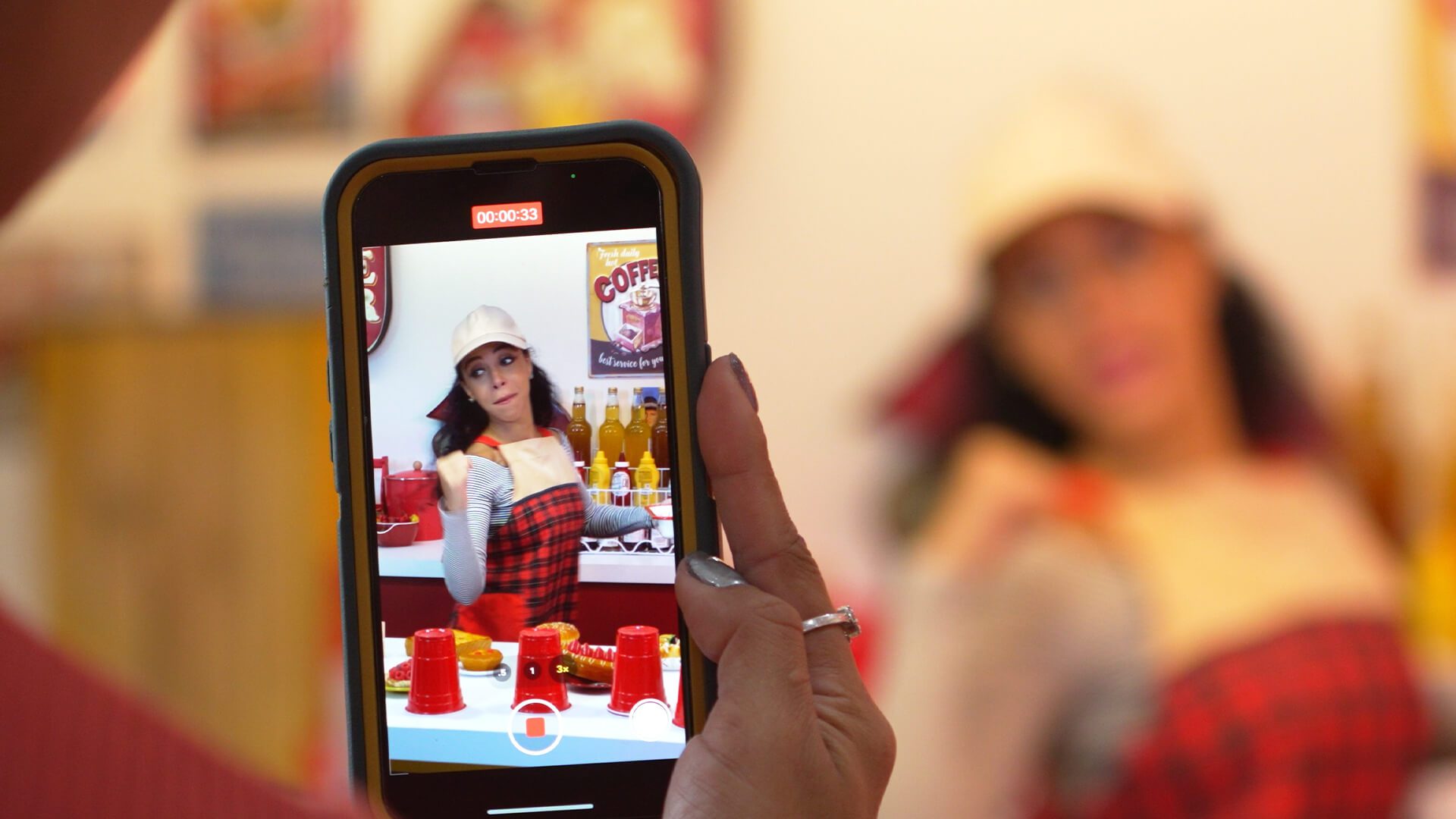 person holding phone recording women advertising a product